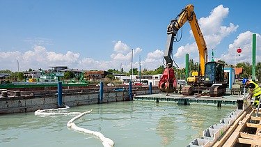 Lánctalpas kotró a kikötőben